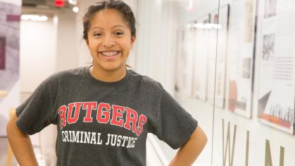 smiling student wears Rutgers Criminal Justice t-shirt